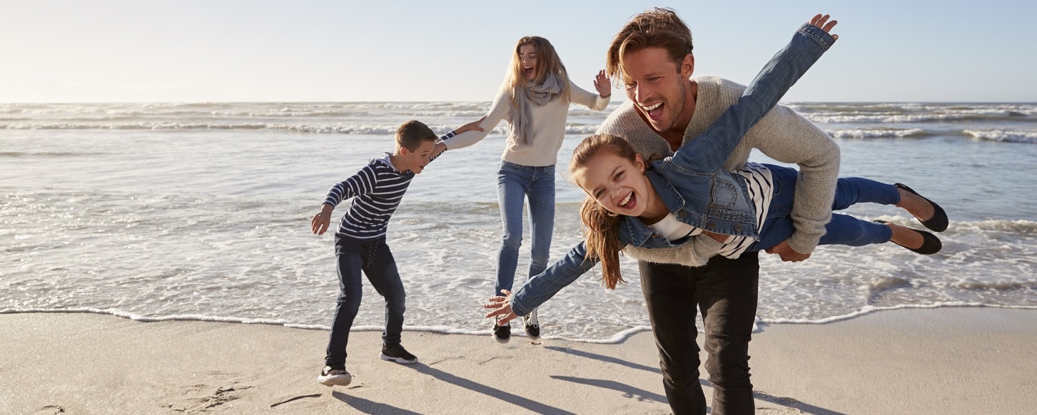 Parents With Children Having Fun On Winter Beach Together