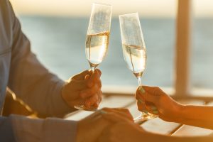 Happy couple drinks champagne on a yacht